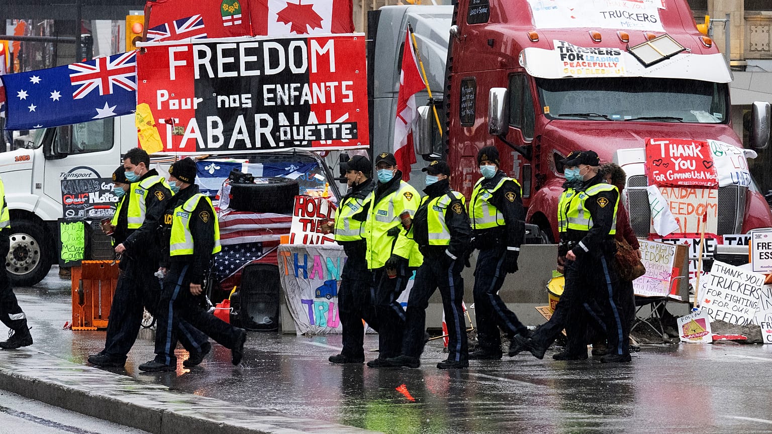 Des officiers de police marchent face aux manifestants qui bloquent Ottawa avec leurs camions, le 17 février 2022, Canada