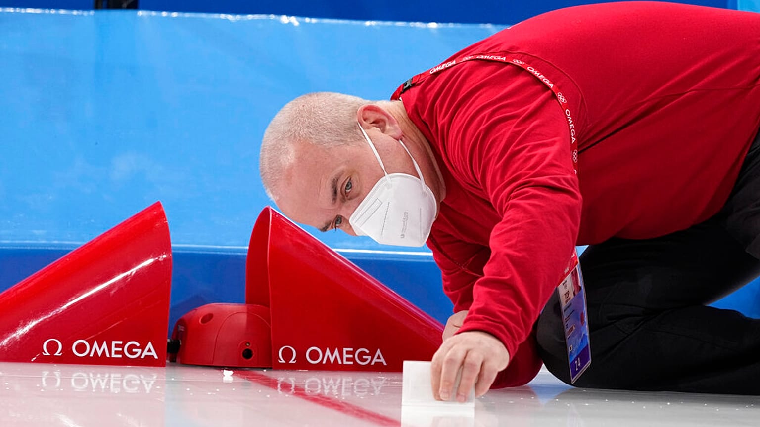 Um técnico da Omega instala a tecnologia na meta antes da corrida de 5 mil metros em patins