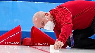 Um técnico da Omega instala a tecnologia na meta antes da corrida de 5 mil metros em patins