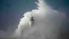 Waves crash over the Newhaven harbour breakwater and lighthouse, as Storm Eunice hits Newhaven, on the south coast of England, Friday, Feb. 18, 2022