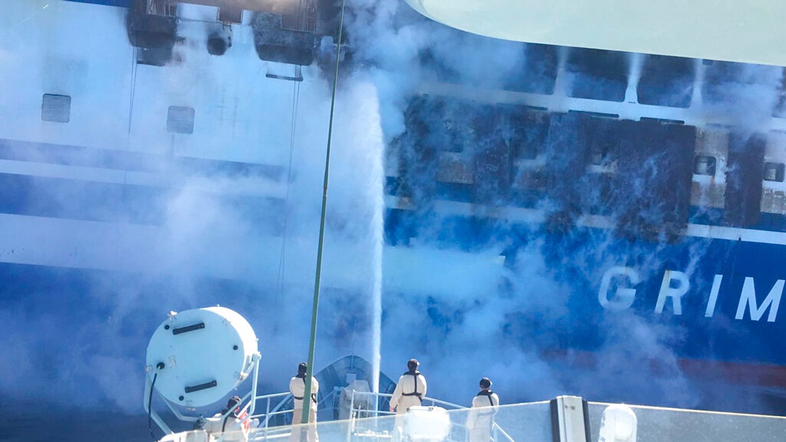 Firefighters hoses down the burning Euroferry Olympia with 291 people on board near the Greek island of Corfu, Friday, Feb. 18, 2022.