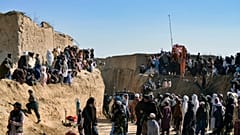 Afghan people gather as rescuers try to reach and rescue a boy trapped down a well in the Afghan village of Shokak, on February 17, 2022.
