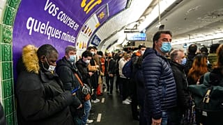 Maszkot viselő emberek egy franciaországi metróállomáson.