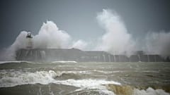 Wellen brechen über dem Leuchtturm von Newhaven an der Südküste Englands
