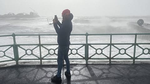 A man on the boardwalk of the Brighton Palace Pier 