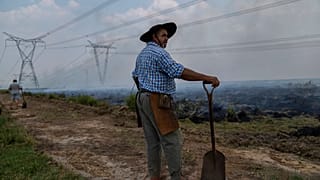 Un agricultor hace una pausa en su trabajo para ayudar a extinguir un incendio cerca de Ituzaingo, provincia de Corrientes, Argentina, el sábado 19 de febrero de 2022.
