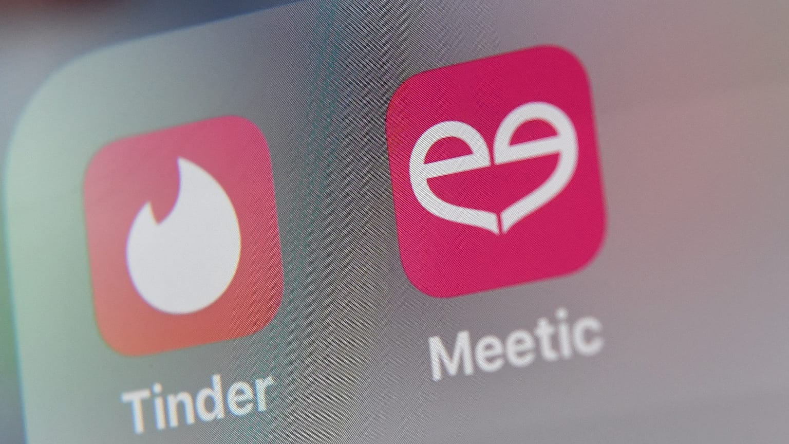 شعار تطبيقات المواعدة الأمريكي Tinder وMeetic على شاشة جهاز لوحي.