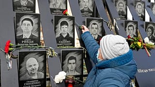 Una mujer coloca una flor en el memorial dedicado a los caídos en la revolución de Maidán, Kiev, Ucrania