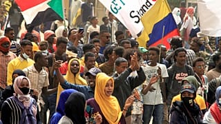 متظاهرون يرفعون أعلام السودان خلال الاحتجاجات المستمرة للمطالبة بالحكم المدني والتنديد بالإدارة العسكرية  في جنوب العاصمة الخرطوم في 20 فبراير 2022.