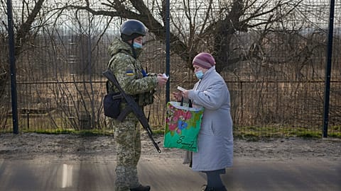 A Ukrainian serviceman checks the documents of a woman crossing to government controlled areas from pro-Russian separatists controlled territory in Stanytsia Luhanska