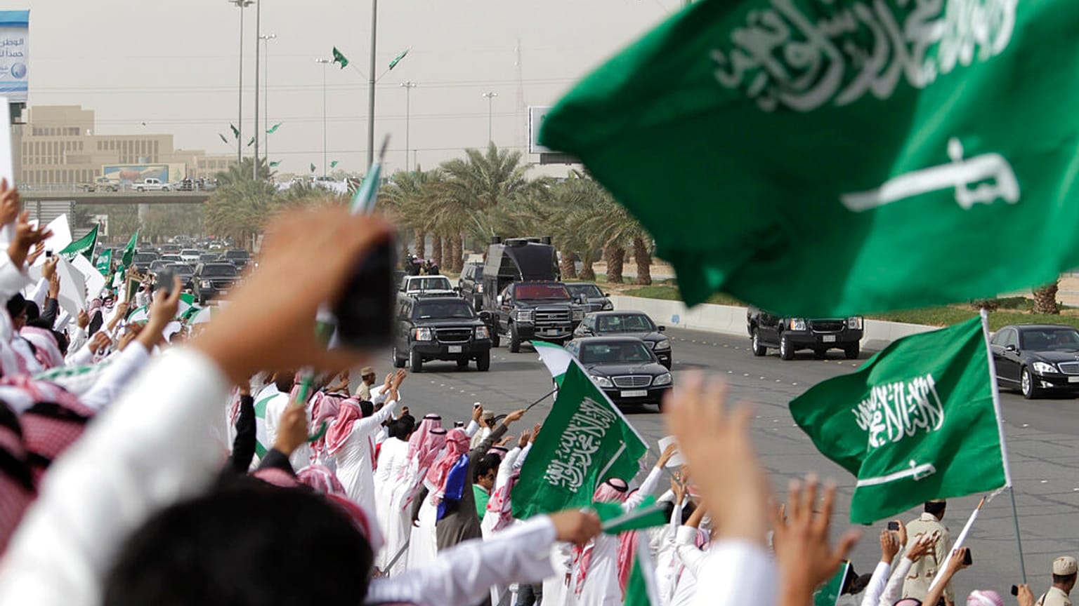 سعوديون يلوحون ويهتفون للترحيب بقافلة العاهل السعودي الملك عبد الله أثناء مروره بهم من المطار وعبر شوارع الرياض، المملكة العربية السعودية، الأربعاء 23 فبراير 2011.