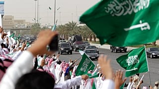 سعوديون يلوحون ويهتفون للترحيب بقافلة العاهل السعودي الملك عبد الله أثناء مروره بهم من المطار وعبر شوارع الرياض، المملكة العربية السعودية، الأربعاء 23 فبراير 2011.