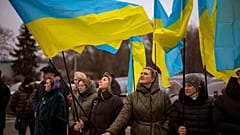 Women hold Ukrainian flags as they gather to celebrate a Day of Unity in Odessa, Ukraine, Wednesday, Feb. 16, 2022.