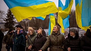 Women hold Ukrainian flags as they gather to celebrate a Day of Unity in Odessa, Ukraine, Wednesday, Feb. 16, 2022.