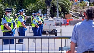 عناصر الشرطة تقف أمام البرلمان بينما يحتل المتظاهرون المناهضون للقاح محيط المبنى، في ويلينغتون، في 22 فبراير 2022.