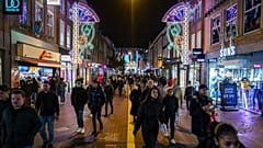 People walk in brightly lit streets of Eindhoven, the Netherlands, where energy poverty is rife.