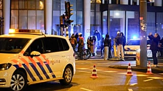 Police vehicles cordon off a wide area in Amsterdam, Netherlands, Feb. 22, 2022, where an armed person is holed up in the Amsterdam Apple Store