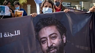 والدة عمر الراضي، الصحفي والناشط المغربي االمتهم بالاغتصاب وتلقي أموال أجنبية لغرض الإضرار بـ "أمن الدولة"، تحمل صورته خلال مظاهرة في الدار البيضاء، المغرب، 22 سبتمبر 2020