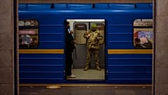 A Ukrainian army officer looks at his phone in a local train in Kyiv, Ukraine, Wednesday, Feb. 23, 2022.
