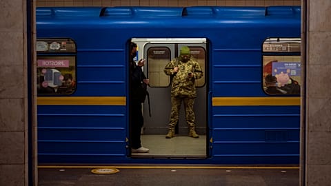 A Ukrainian army officer looks at his phone in a local train in Kyiv, Ukraine, Wednesday, Feb. 23, 2022.