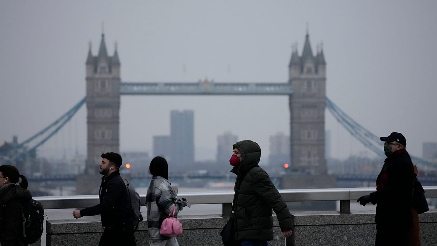 Workers walk over London Bridge towards the City of London financial district.