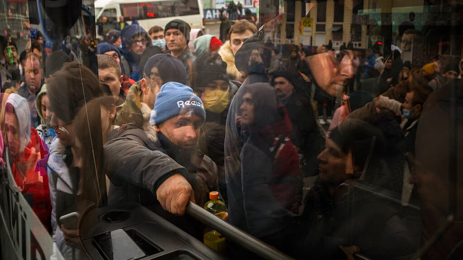 Habitantes de Kiev tratan de subirse a un autobús para salir de la capital ucraniana