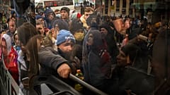 Habitantes de Kiev tratan de subirse a un autobús para salir de la capital ucraniana