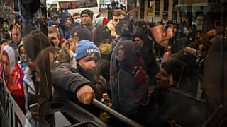 Habitantes de Kiev tratan de subirse a un autobús para salir de la capital ucraniana