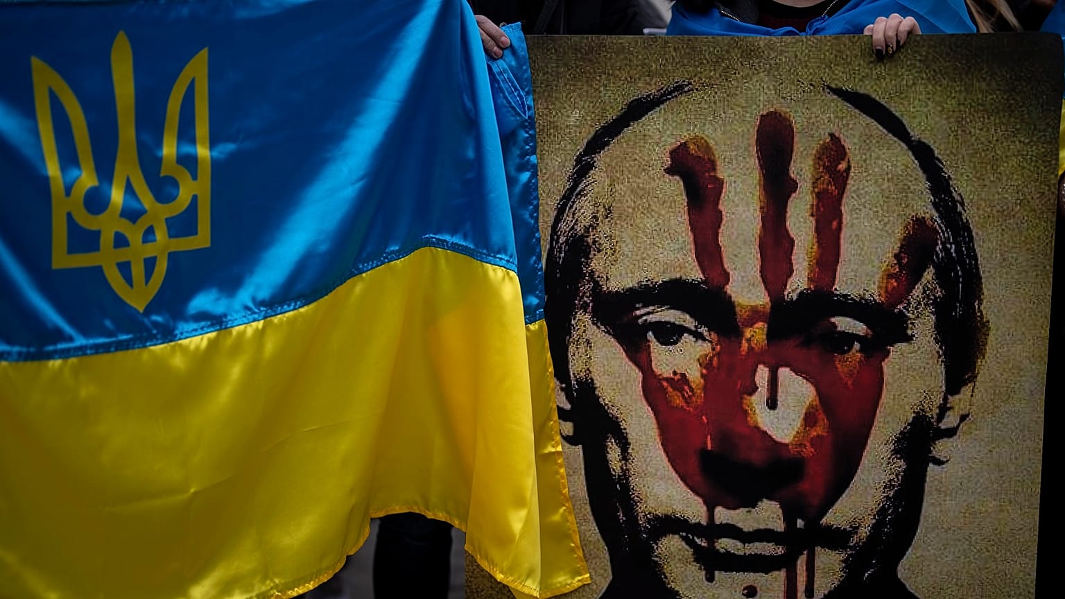 A protestor holds a banner depicting Russian President Vladimir Putin during a demonstration in front of the Russian Embassy in Madrid, Spain, Thursday, Feb. 24, 2022.