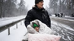 An elderly woman is coated in snow as she sits in a wheelchair after being evacuated from Irpin, on the outskirts of Kyiv, Ukraine. March 8, 2022
