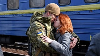Un couple s'enlace avant qu'elle ne monte dans le train en gare de Kramatorsk en direction de l'ouest de l'Ukraine, dimanche 27 février 2022