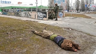 Ukrán katona figyeli a környéket Kijevben - mellette egy lelőtt katona holtteste