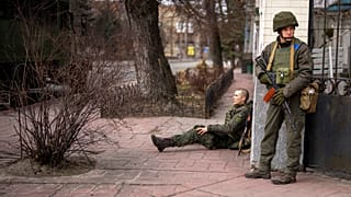 Un soldado ucraniano sentado, herido por el fuego cruzado en la ciudad de Kyiv, Ucrania