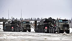 Military trucks carry tanks as a part of additional British troops and military equipment upon their arrival at Estonia