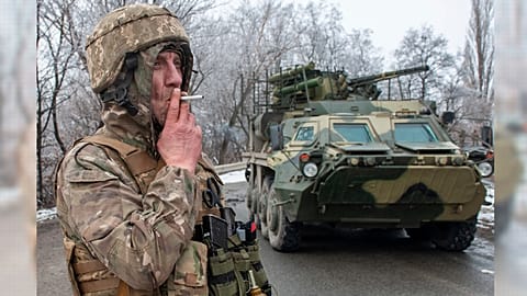 A Ukrainian soldier smokes a cigarette on his position at an armored vehicle outside Kharkiv