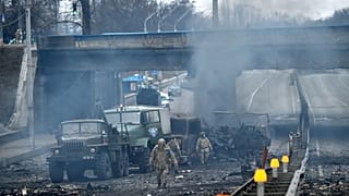 Des membres des services ukrainiens recherchent et ramassent des obus non explosés après un combat avec un groupe de raiders russes dans la capitale ukrainienne de Kyiv.