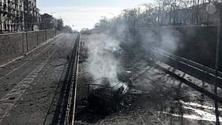 Горящие обломки военных грузовиков на попавшей в субботу под обстрел улице Киева