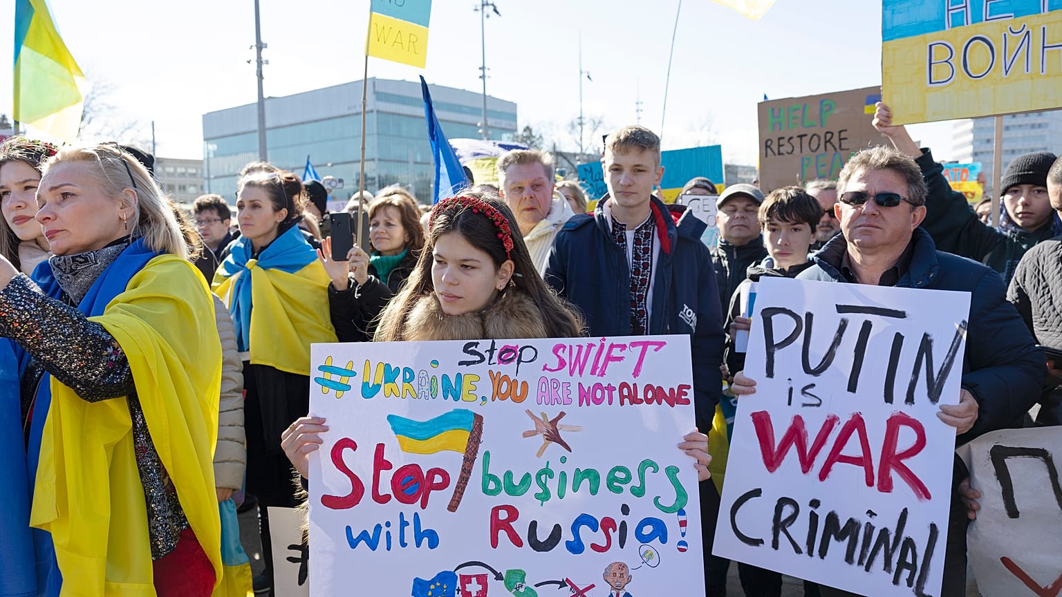 Demonstrators hold placards while protesting Russia's military operation against Ukraine during a rally on the place of the United Nations in Geneva, Switzerland, on Saturday