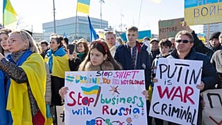 Demonstrators hold placards while protesting Russia's military operation against Ukraine during a rally on the place of the United Nations in Geneva, Switzerland, on Saturday