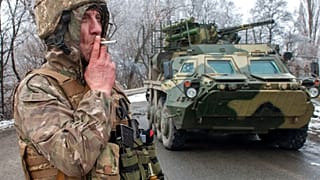 Um soldado ucraniano fuma um cigarro ao pé de um veículo blindado nos arredores de Kharkiv