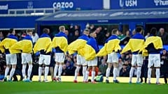 Everton players hold Ukrainian flags before the English Premier League soccer match