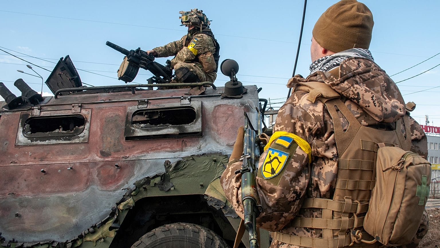 Украинские солдаты под Харьковом осматривают сгоревшую российскую бронемашину