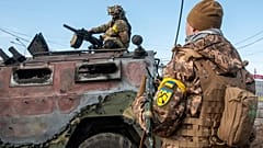 Украинские солдаты под Харьковом осматривают сгоревшую российскую бронемашину