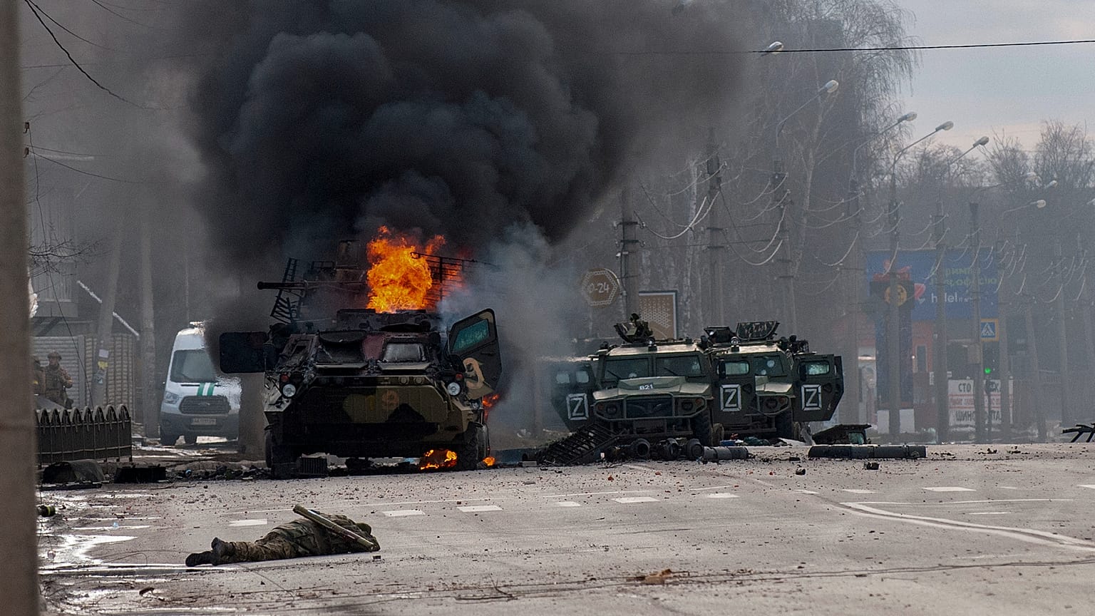 Un soldat gît au sol devant des véhicules blindés russes abandonnés après des combats à Kharkiv, dans l'est de l'Ukraine, ce dimanche