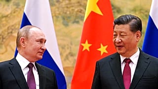 Chinese President Xi Jinping, right, and Russian President Vladimir Putin talk to each other during their meeting in Beijing