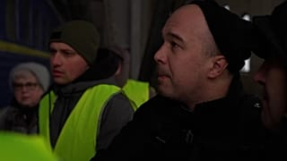 Man helping wife onto train 