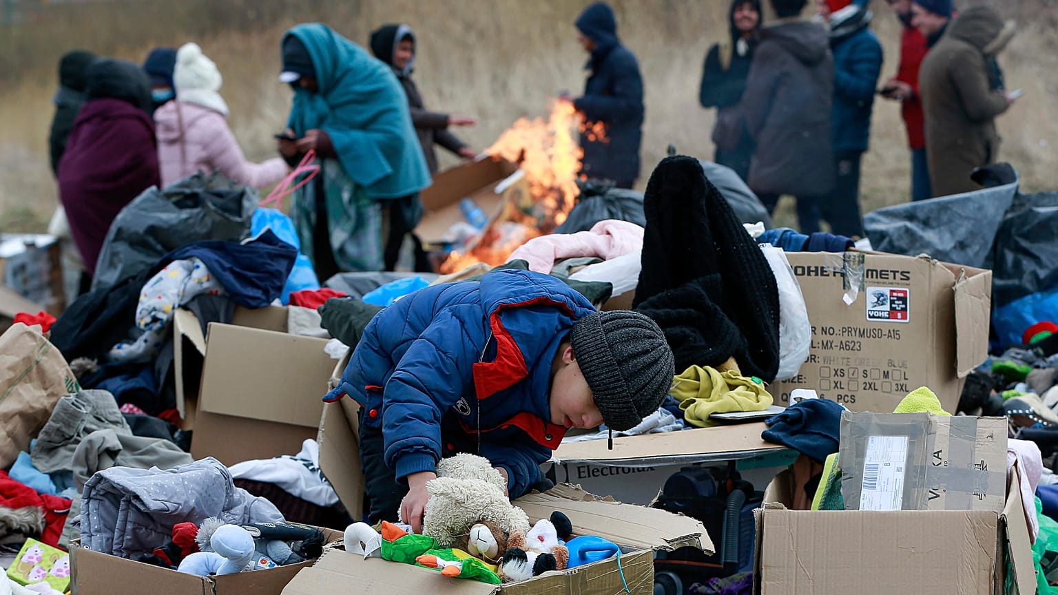 A child collects toys near a clothes donation point as refugees fleeing conflict in Ukraine arrive at the Medyka border crossing in Poland on 28 February 2022.