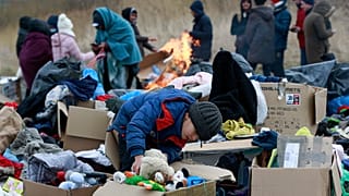 A child collects toys near a clothes donation point as refugees fleeing conflict in Ukraine arrive at the Medyka border crossing in Poland on 28 February 2022.