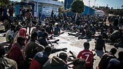ARCHIVO - Migrantes descansan en un centro de retención tras cruzar las vallas que separan el enclave español de Melilla de Marruecos, en Melilla, España, 2/3/2022