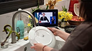 Женщина моет посуду под обращение Эммануэля Макрона к нации. Лион, Франция. 2 марта 2022 года